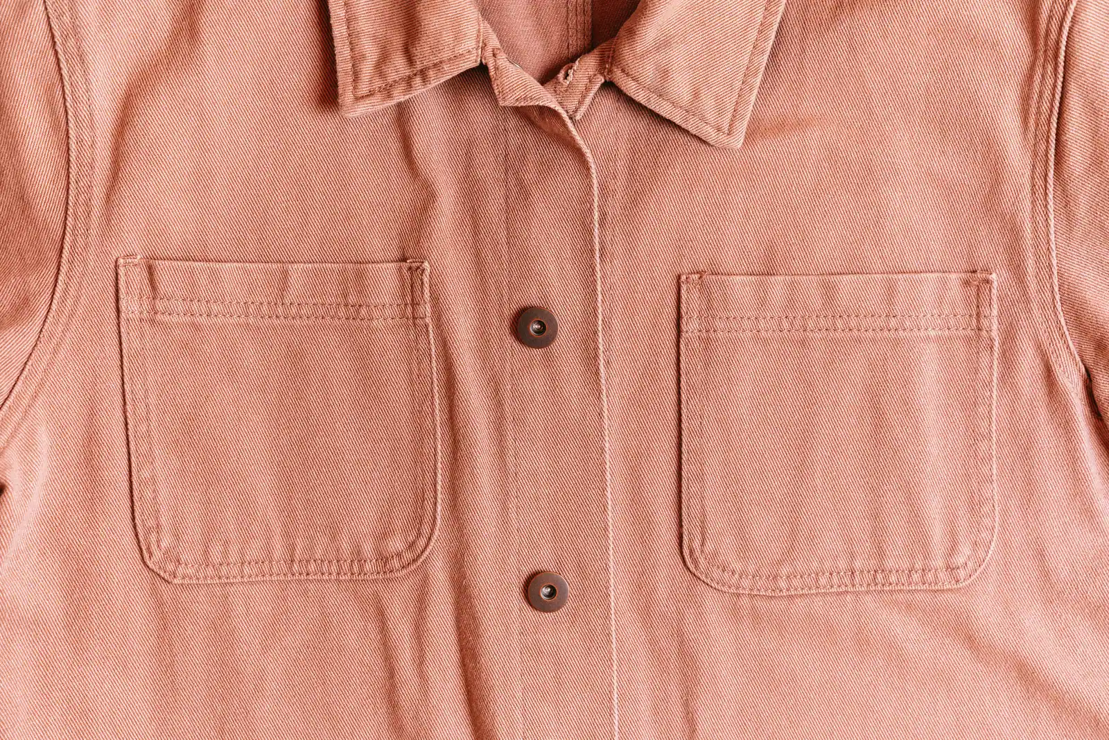 A faded coral cotton overshirt with two patch pockets.